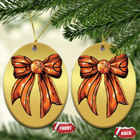 Two gold oval Christmas ornaments with orange ribbon bow art and gold hanging cords