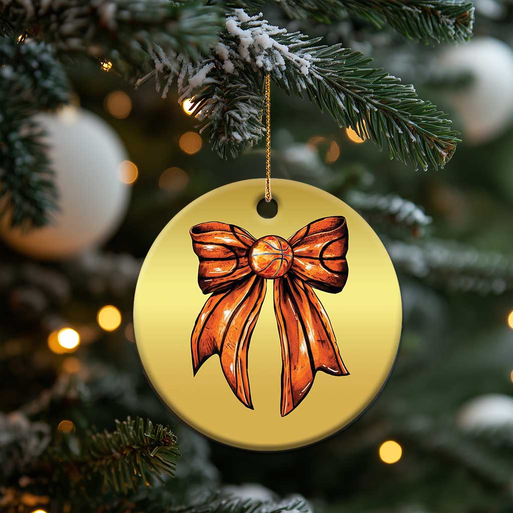 Gold round Christmas ornament featuring an orange ribbon bow and gold hanging cord