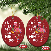 Two red oval flamingo Christmas ornaments with gold strings and “FA LA LA MIN GO” text.
