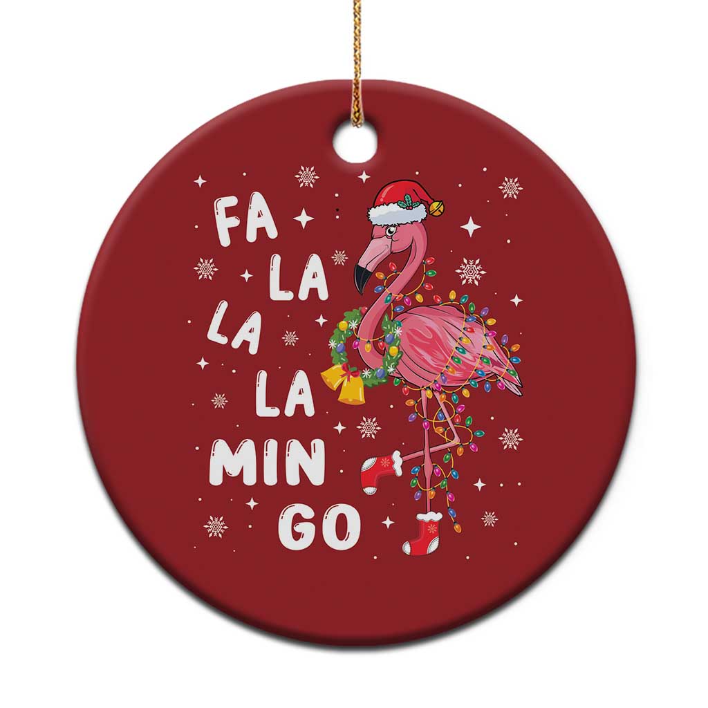 Red round flamingo Christmas ornament with hanging gold string and “FA LA LA MIN GO” text.