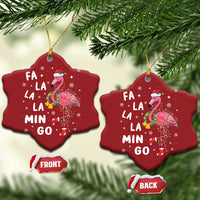 Two red star-shaped flamingo Christmas ornaments with gold strings; “FA LA LA MIN GO” text.