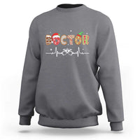 Light gray crewneck sweatshirt with “DOCTOR” graphic and stethoscope design