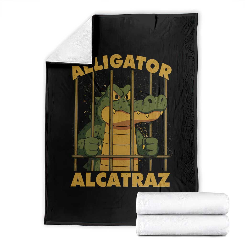 Black throw blanket with cartoon alligator behind bars graphic, folded with white underside