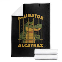 Black throw blanket with cartoon alligator behind bars graphic, folded with white underside