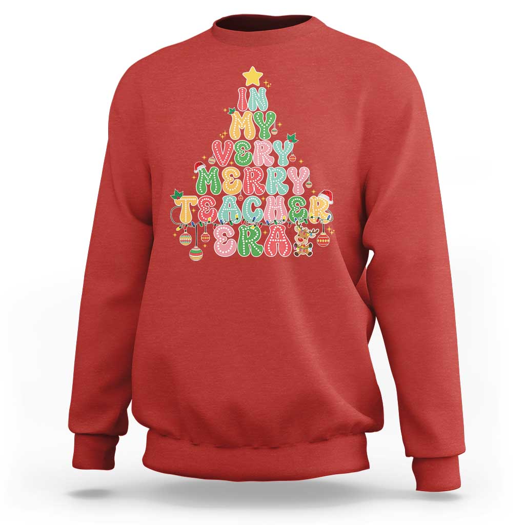 Red teacher sweatshirt with colorful “Merry Teacher” holiday graphic on front.
