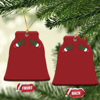 Two red bell-shaped Christmas ornaments with green skeleton hands and gold hanging loops