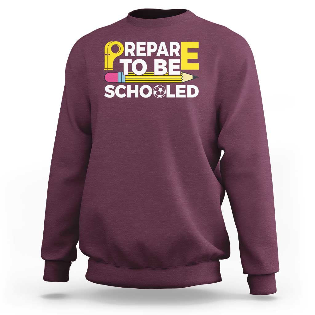 Maroon crewneck sweatshirt with “Prepare To Be Schooled” teacher graphic on front
