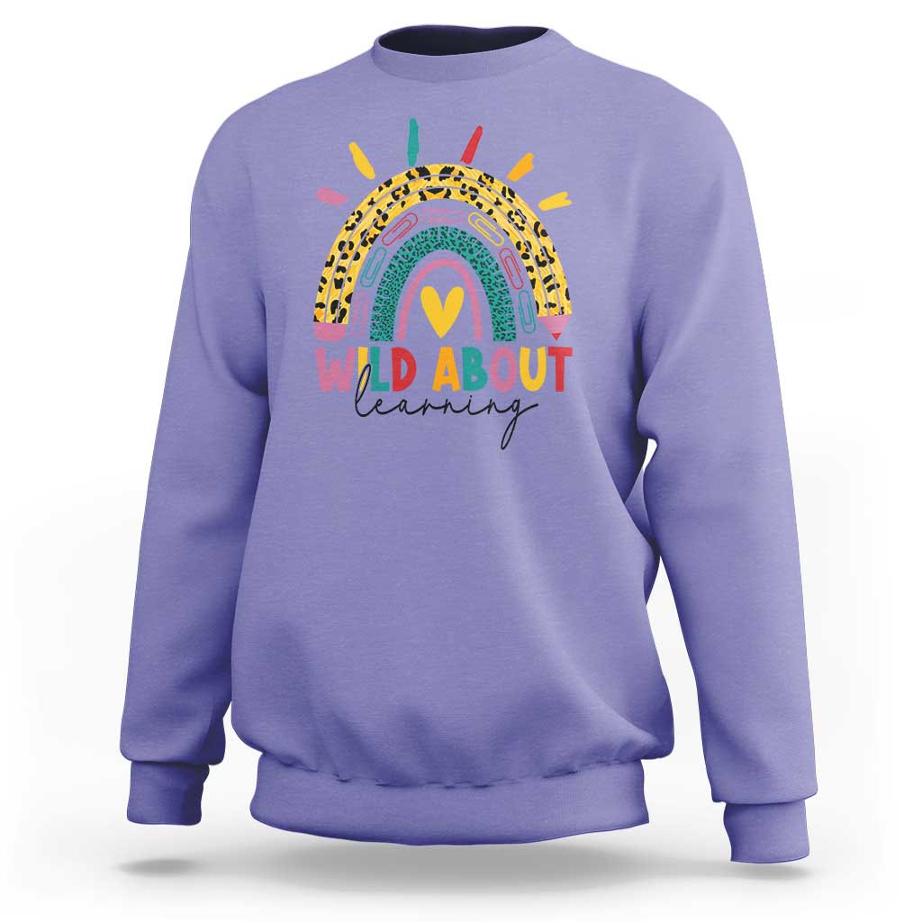 Violet back-to-school sweatshirt with rainbow leopard graphic and “WILD ABOUT learning” text