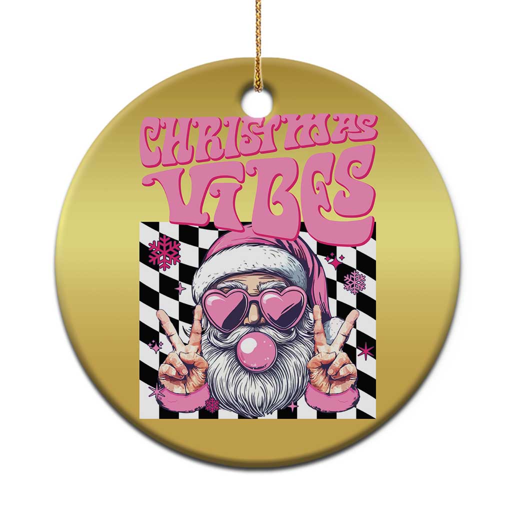 Gold circular Christmas ornament with Santa face graphic and hanging gold string.
