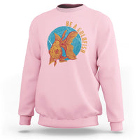 Light pink sweatshirt with goldfish graphic and vertical text "BE A GOLDFISH" on chest