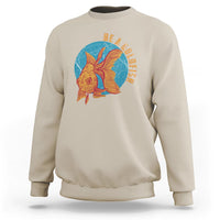 Sand sweatshirt with goldfish graphic and vertical text "BE A GOLDFISH" on chest