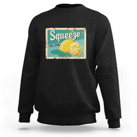 Black crewneck sweatshirt with front “Squeeze the Day” lemon graphic