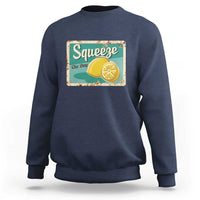 Navy crewneck sweatshirt with front “Squeeze the Day” lemon graphic