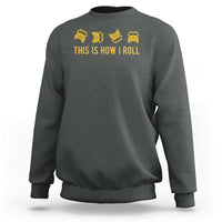 Charcoal crewneck sweatshirt with yellow bus icons and 'THIS IS HOW I ROLL' print