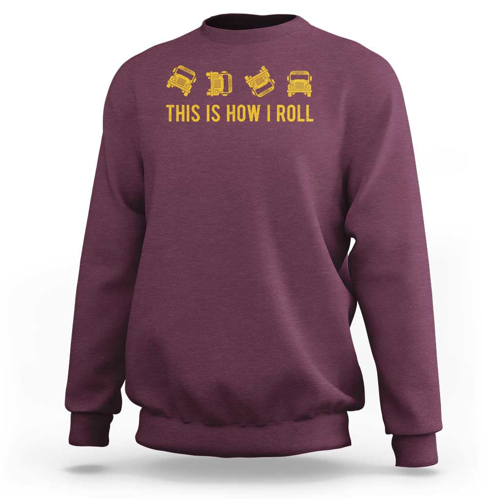 Maroon crewneck sweatshirt with yellow bus icons and 'THIS IS HOW I ROLL' print