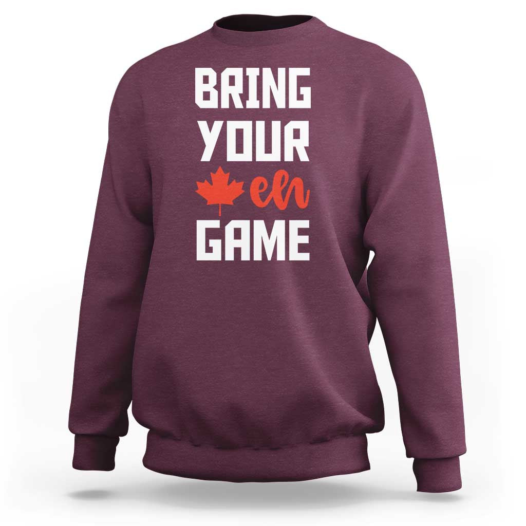 Maroon sweatshirt with “BRING YOUR EH GAME” text and orange maple leaf graphic