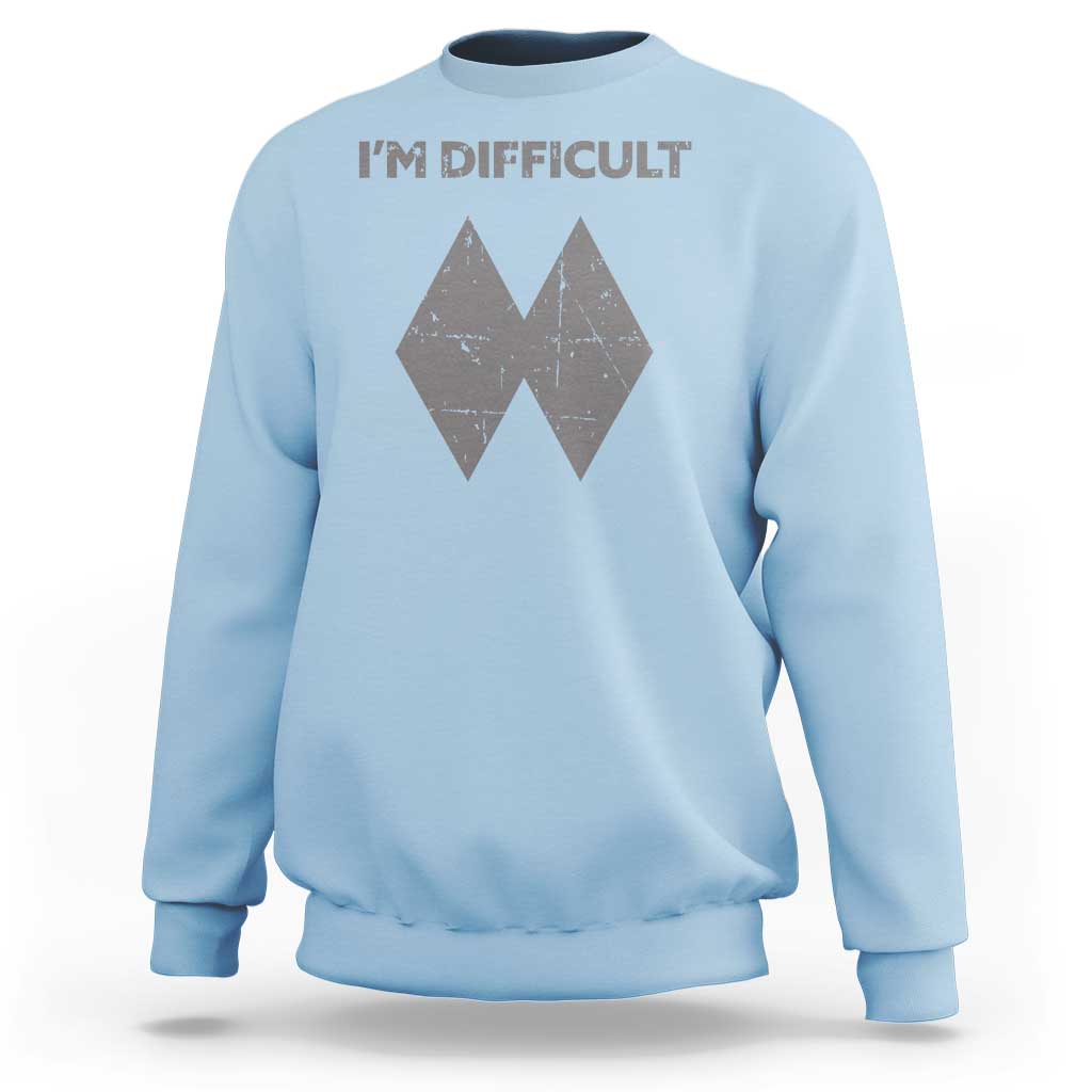 Light blue crewneck sweatshirt with 'I'M DIFFICULT' text and double diamond ski graphic