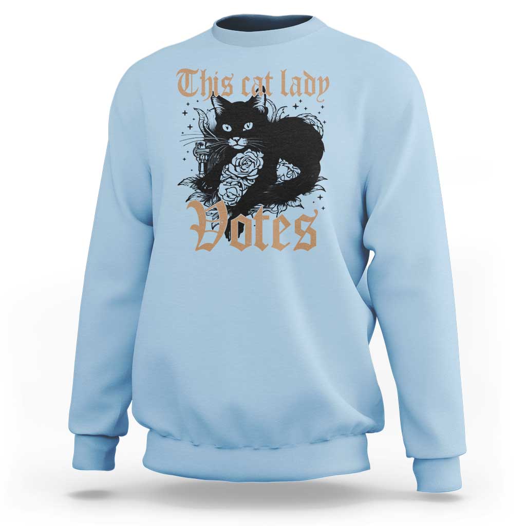 Light blue sweatshirt with cat-and-roses "Votes" graphic at center