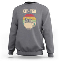 Charcoal gray crewneck sweatshirt with 'KIT-TEA' cat in tea cup graphic