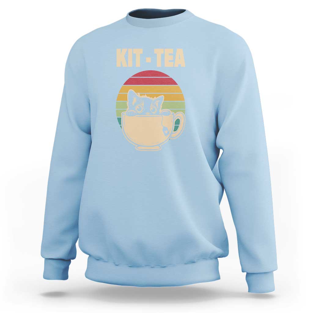 Light blue crewneck sweatshirt with 'KIT-TEA' cat in tea cup graphic