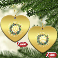 Two gold heart-shaped Christmas ornaments with wreath and nativity star, hanging loops