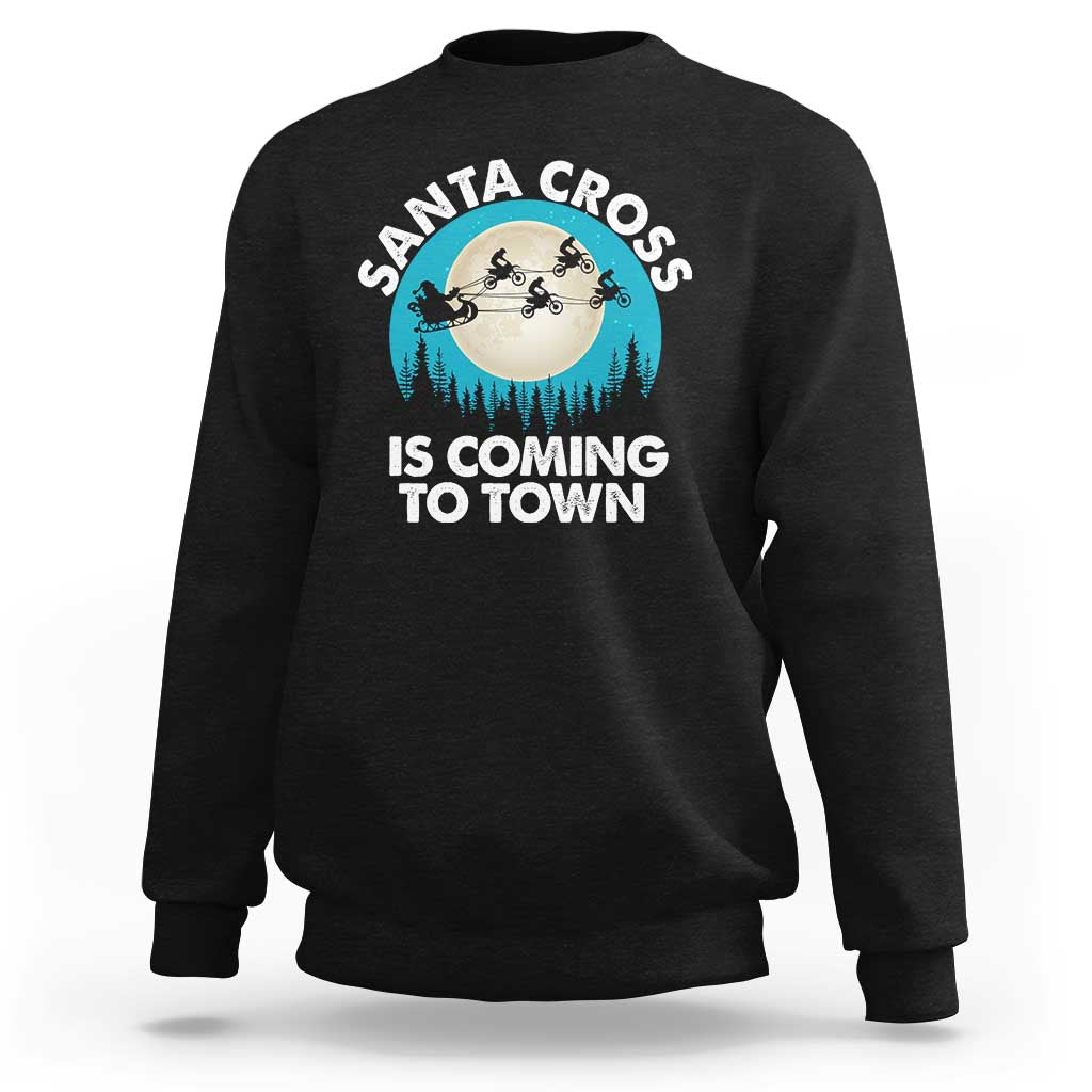 Black crewneck sweatshirt with Santa Cross graphic and 'IS COMING TO TOWN' print