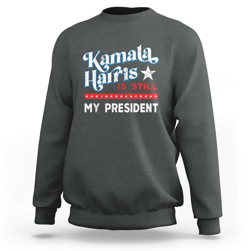 Dark heather gray crewneck sweatshirt with vintage star “Kamala Harris is still my president” print