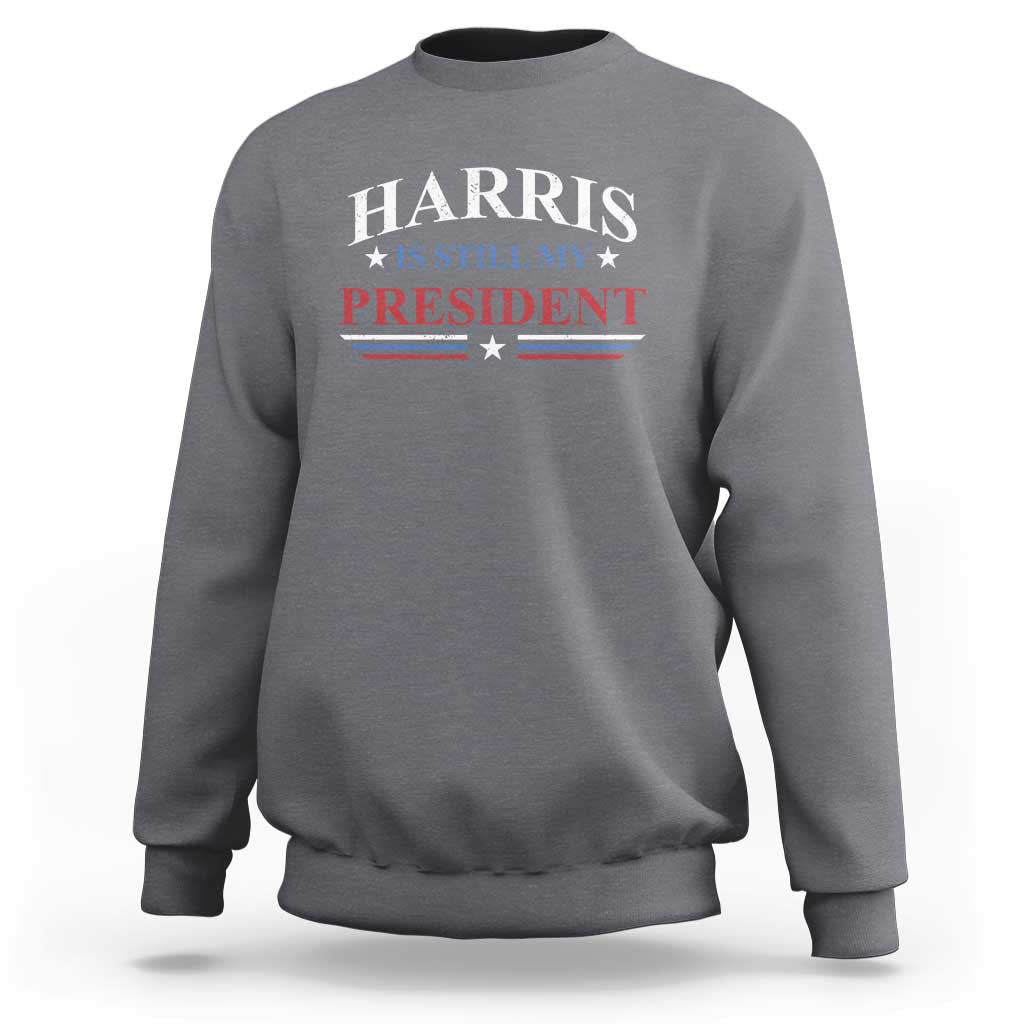 Dark heather gray crewneck sweatshirt with Harris "Still My President" star-striped graphic