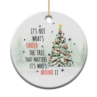 White circular Christmas ornament with tree and quote, hanging with gold string