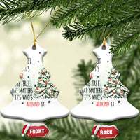 Pair of white bell-shaped Christmas ornaments with tree and quote, hanging from gold strings