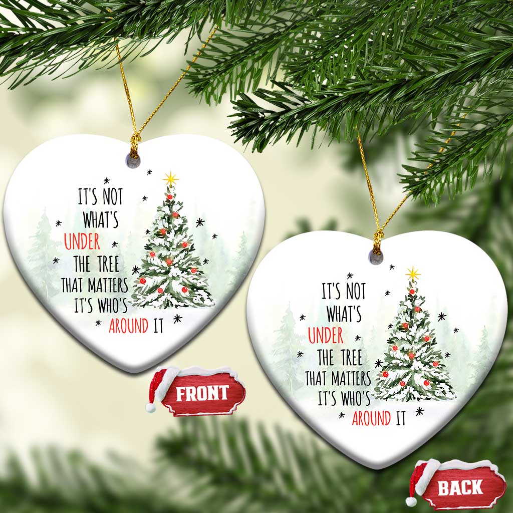 Two white heart-shaped Christmas ornaments with tree and quote, hanging by gold strings