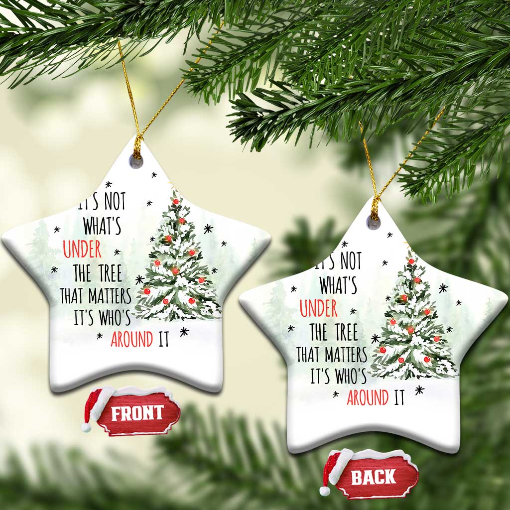 Two white snowflake-shaped Christmas ornaments with tree and quote, hanging by gold strings