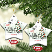 Two white snowflake-shaped Christmas ornaments with tree and quote, hanging by gold strings