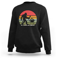 Black crewneck sweatshirt with Bigfoot BBQ chef graphic in red sunset circle