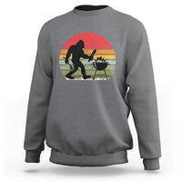 Gray crewneck sweatshirt with Bigfoot BBQ chef graphic in red sunset circle