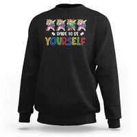 Black crewneck sweatshirt with colorful unicorn graphic and “Dare to be yourself” text