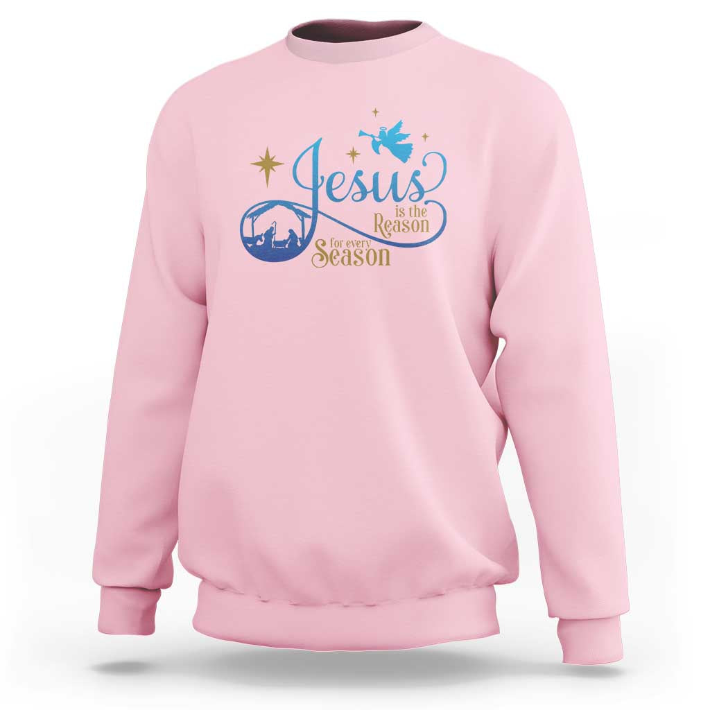 Light pink sweatshirt with blue nativity “Jesus … the Season” graphic on the chest
