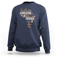 Navy crewneck sweatshirt with 'Education Is Freedom' books graphic at center front