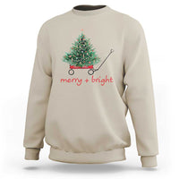 Sand Christmas sweatshirt with wagoned Christmas tree graphic and “merry + bright” text
