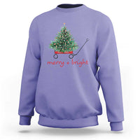 Violet Christmas sweatshirt with wagoned Christmas tree graphic and “merry + bright” text