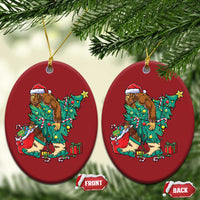 Two red oval hanging ornaments featuring a cartoon Bigfoot Santa decorating a Christmas tree.