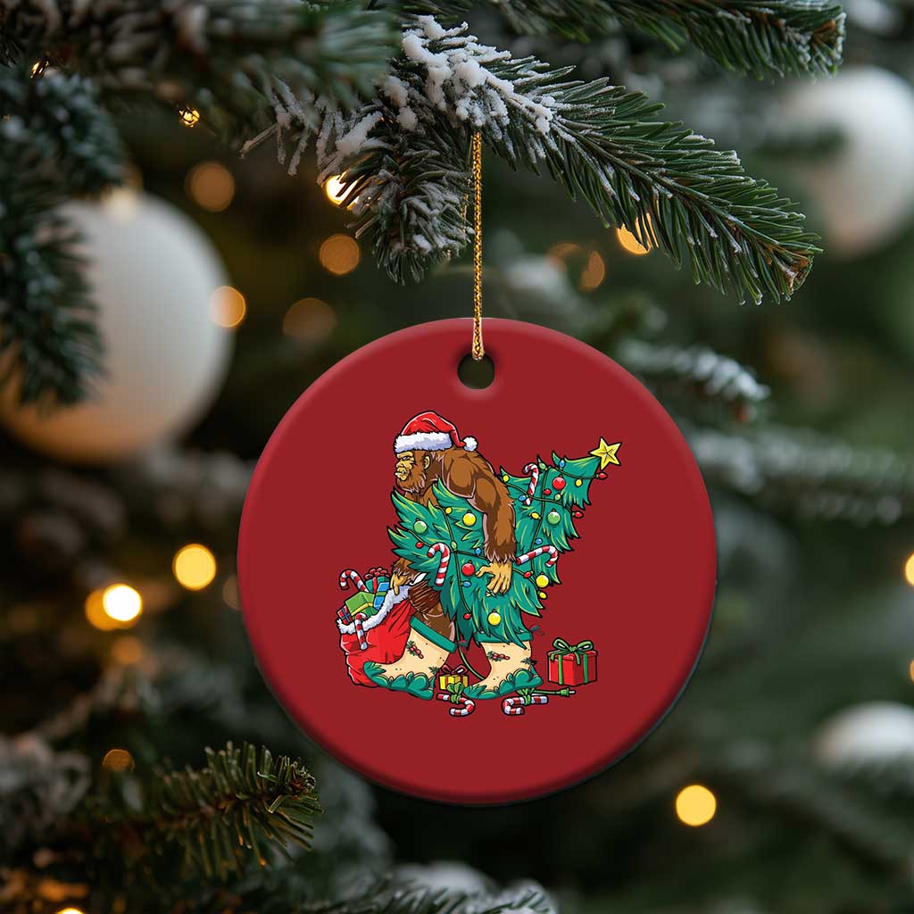 Red round hanging ornament with cartoon Bigfoot Santa holding a Christmas tree star.