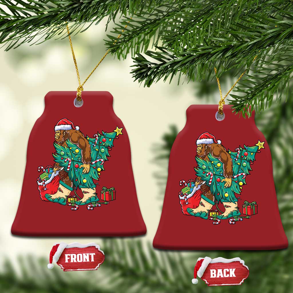 Pair of red bell-shaped holiday ornaments with cartoon Bigfoot Santa decorating a Christmas tree.