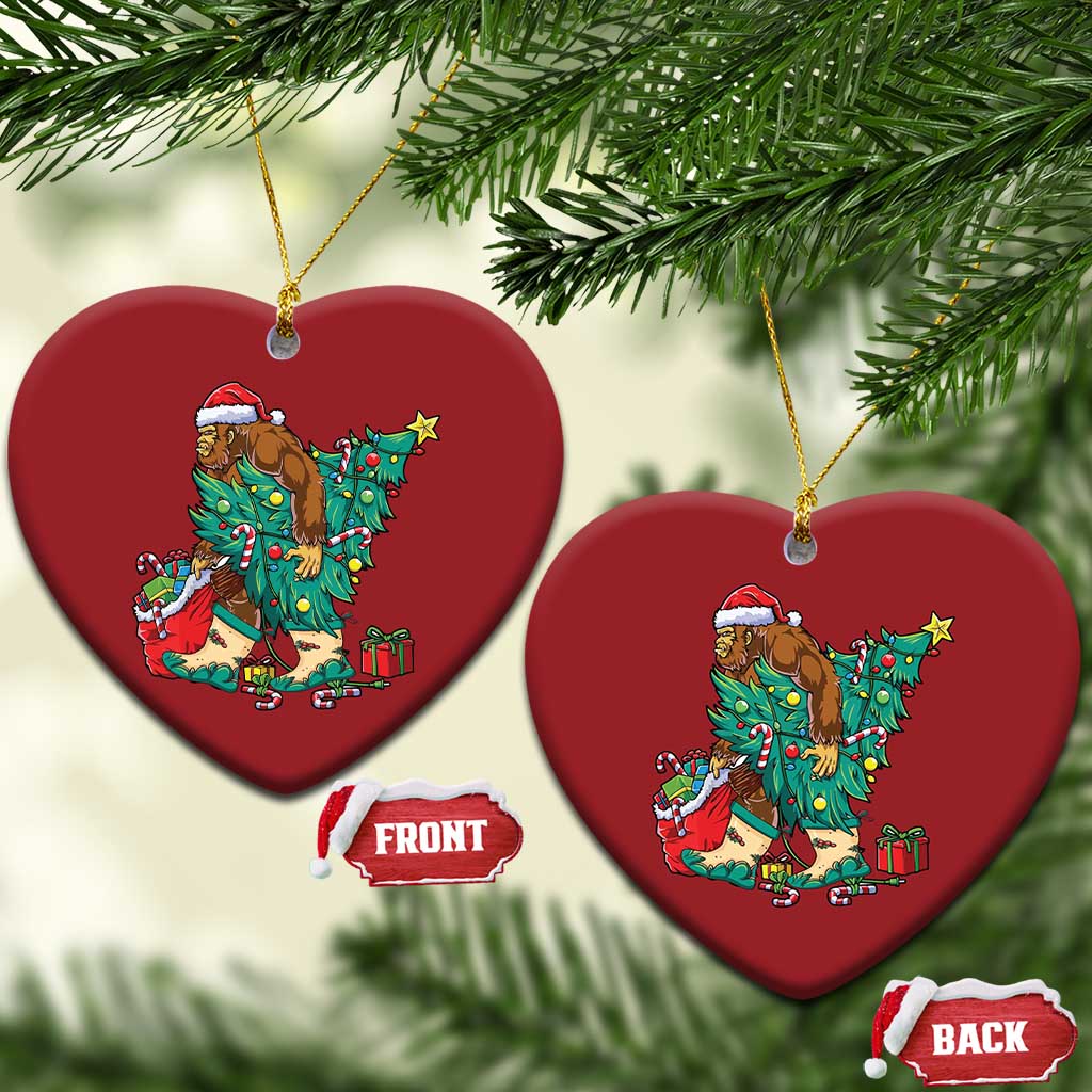 Two red heart-shaped ornaments with cartoon Bigfoot Santa decorating a Christmas tree.