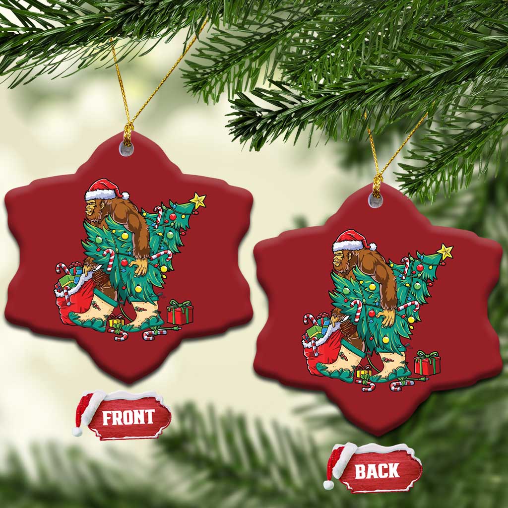Two red snowflake-shaped ornaments with cartoon Bigfoot Santa decorating a Christmas tree.