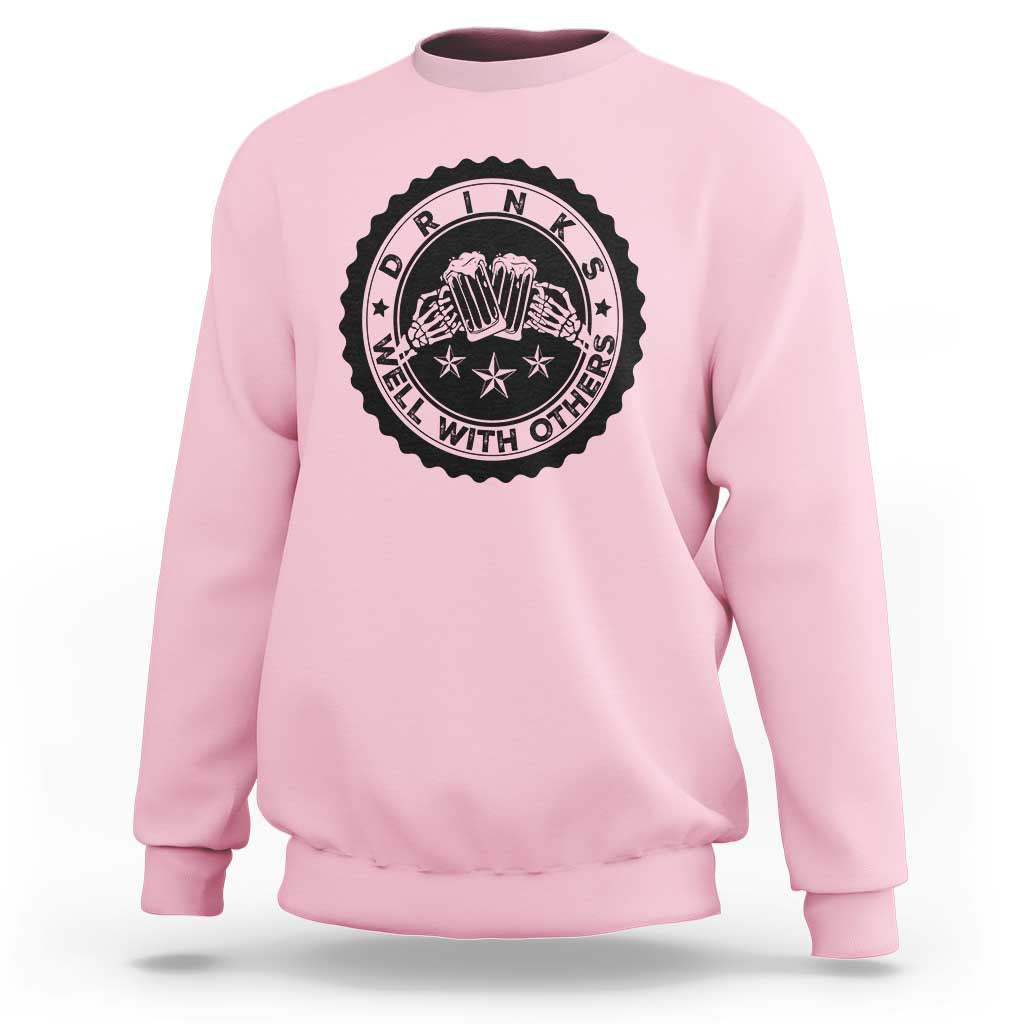 Light pink crewneck sweatshirt with black circular drink graphic on the chest.
