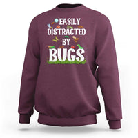 Maroon sweatshirt with colorful “Bugs” insect graphic on the front
