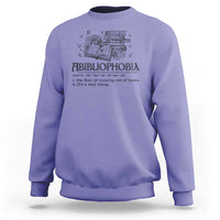 Purple crewneck sweatshirt with book-and-butterfly graphic and bold text design