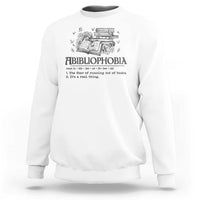 White crewneck sweatshirt with book-and-butterfly graphic and bold text design