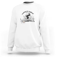 White sweatshirt with open book and flower graphic plus 'Reading is magical' text